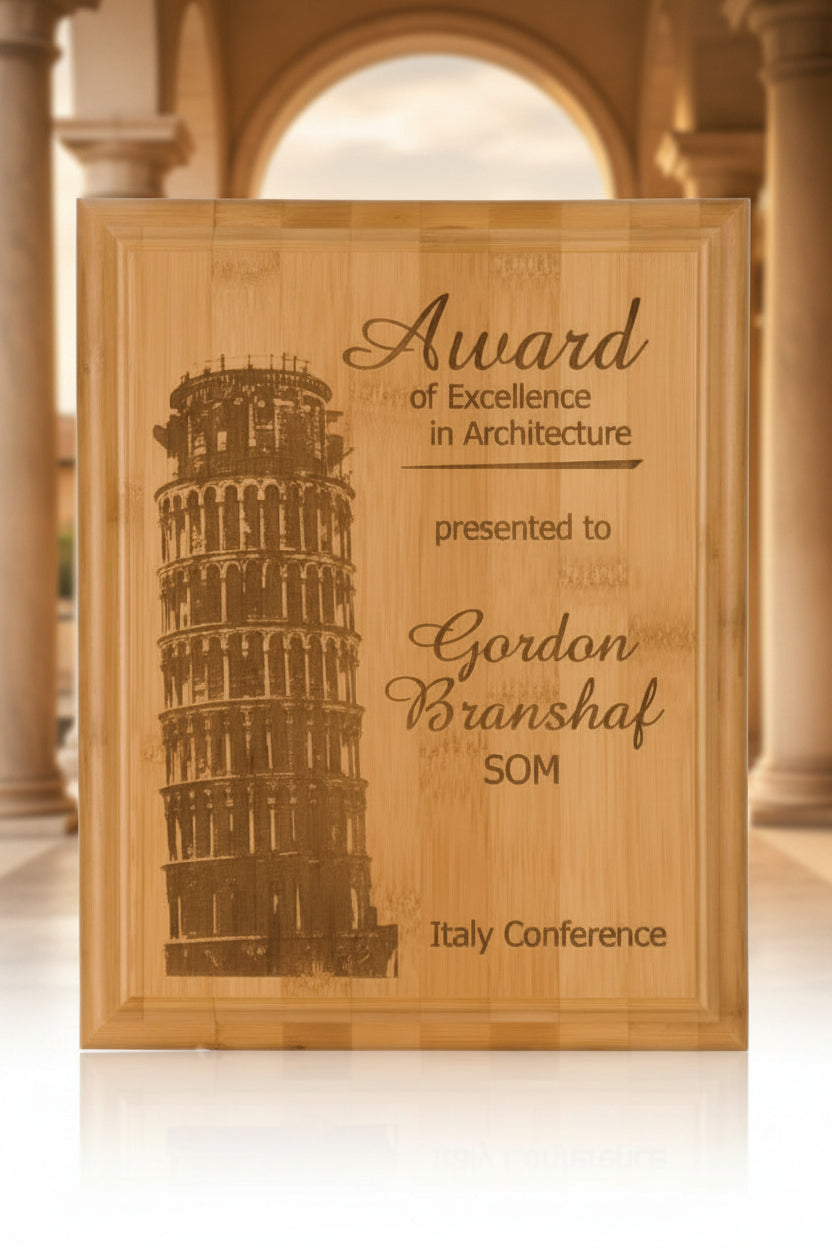 Wooden award plaque with engraved design of the Leaning Tower of Pisa and text.