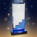 Clear and blue glass award with text on a white background