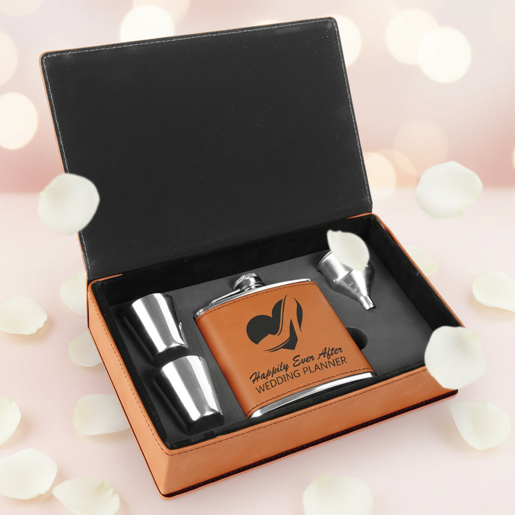 Brown leather flask set with silver components in a black box on a white background