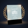 Glass award with engraved text on a black base against a white background