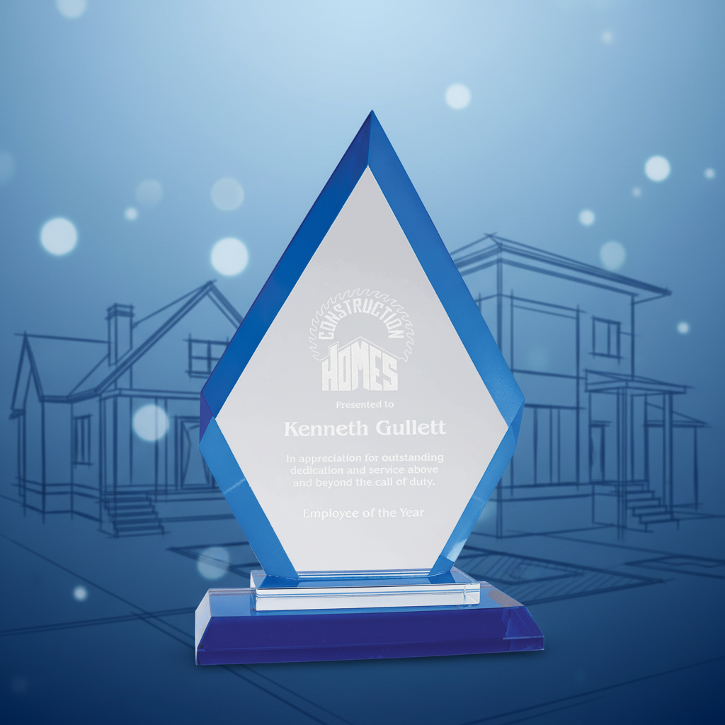 Diamond-shaped glass award with blue base and engraved text on a green background